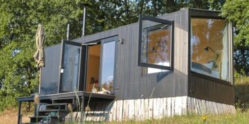 a small house sitting on top of a lush green field