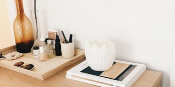 amber glass flower vase near white wall-mounted socket