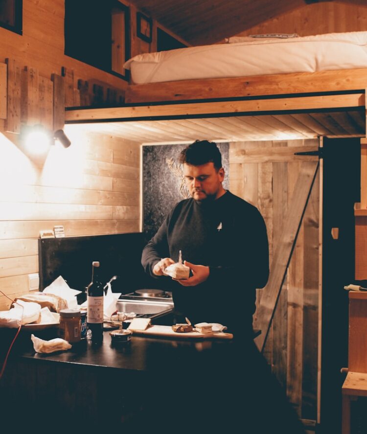 man in black dress shirt standing in front of table