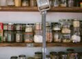 assorted glass jars on white wooden shelf