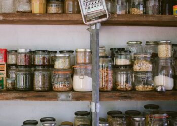 assorted glass jars on white wooden shelf