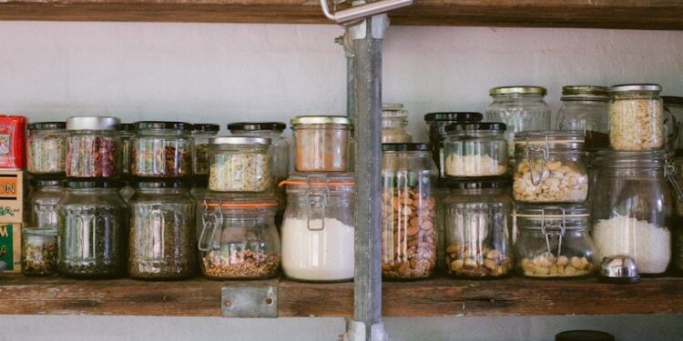 assorted glass jars on white wooden shelf
