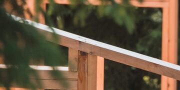 A man riding a skateboard on top of a wooden rail