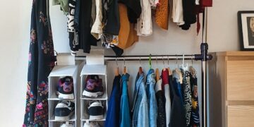 clothes hanged on brown wooden cabinet