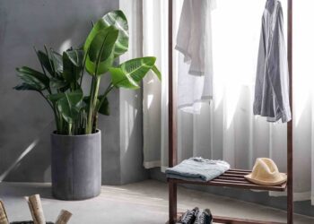 gray dress shirt hang on brown wooden rack in front of window with white curtain