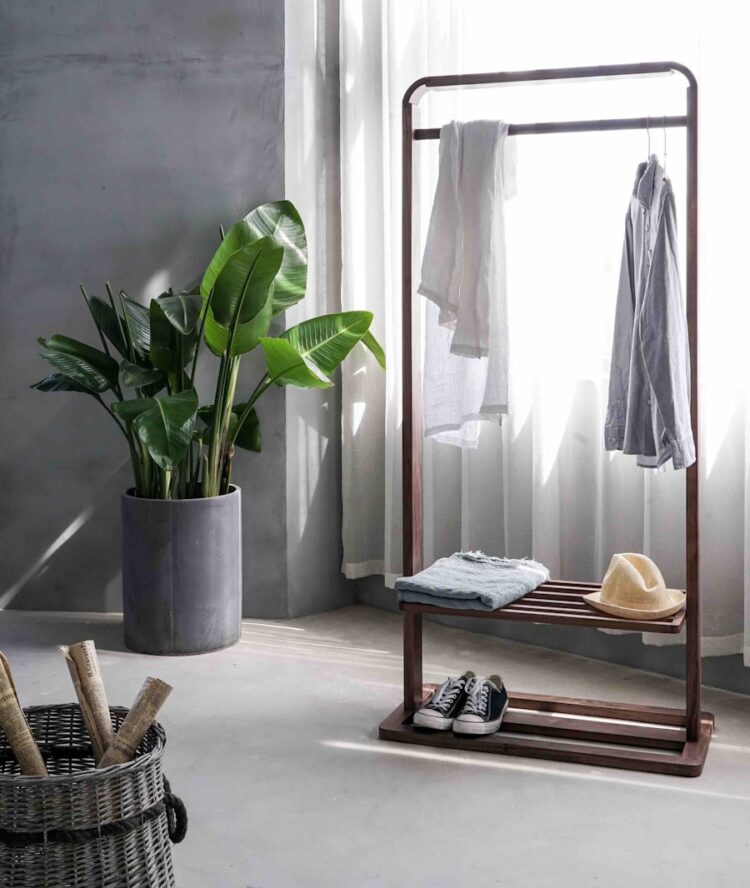 gray dress shirt hang on brown wooden rack in front of window with white curtain