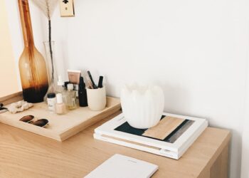 amber glass flower vase near white wall-mounted socket