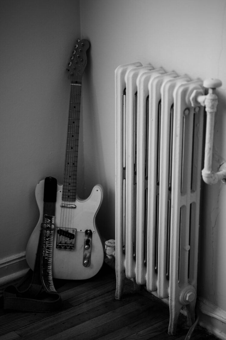a guitar and a radiator in a room
