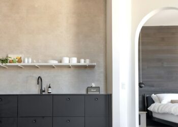 A modern kitchen opens to a bedroom.