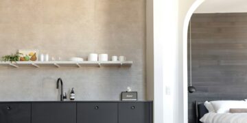 A modern kitchen opens to a bedroom.