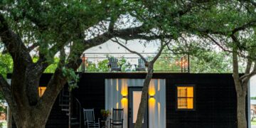 brown wooden house near green tree during daytime