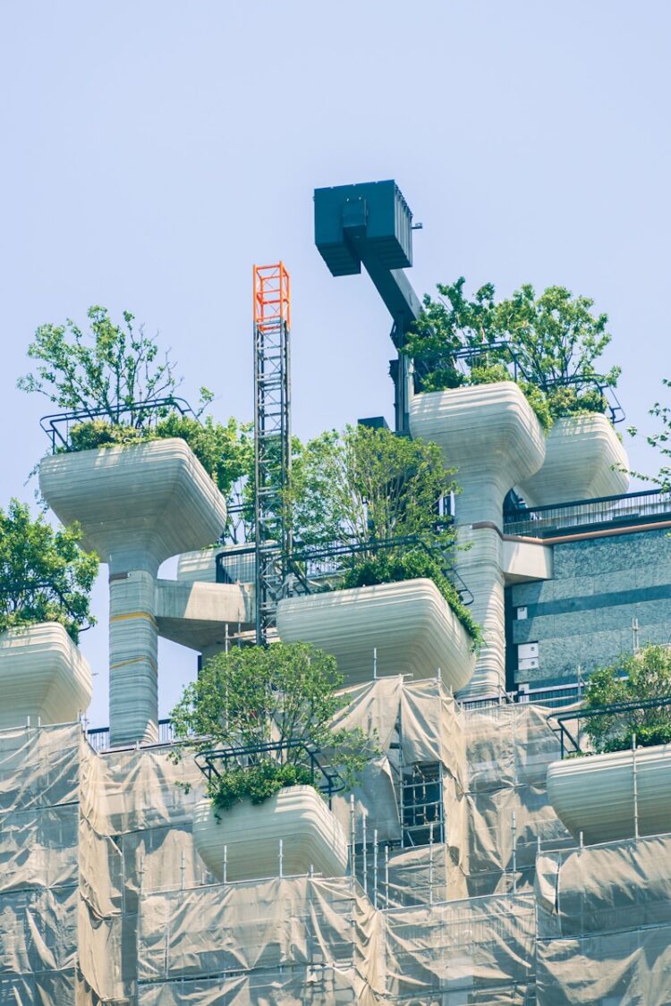 Modern building with green rooftop gardens and scaffolding.