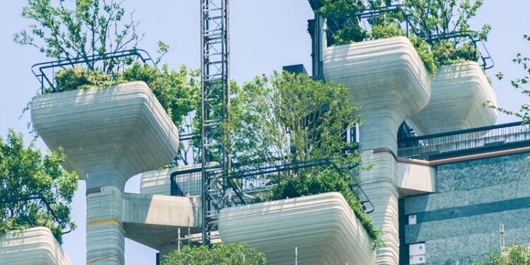 Modern building with green rooftop gardens and scaffolding.