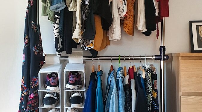 clothes hanged on brown wooden cabinet