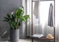 gray dress shirt hang on brown wooden rack in front of window with white curtain