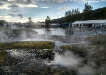 white and black house near green trees under white clouds during daytime