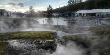 white and black house near green trees under white clouds during daytime