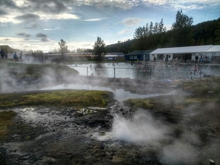white and black house near green trees under white clouds during daytime