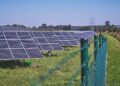 solar panels on green grass field under blue sky during daytime