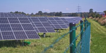 solar panels on green grass field under blue sky during daytime