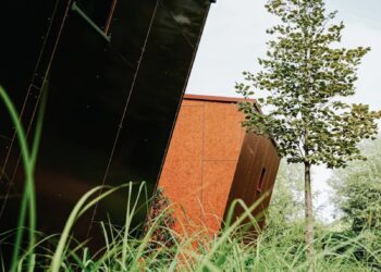 Contemporary buildings surrounded by lush greenery and trees outdoors.