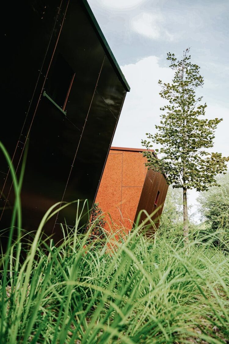 Contemporary buildings surrounded by lush greenery and trees outdoors.
