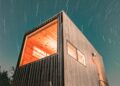 Night view of a modern tiny house illuminated under a starry sky in Wimberley, Texas.