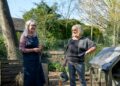 Smiling senior women enjoying gardening in a sunny backyard garden setting.