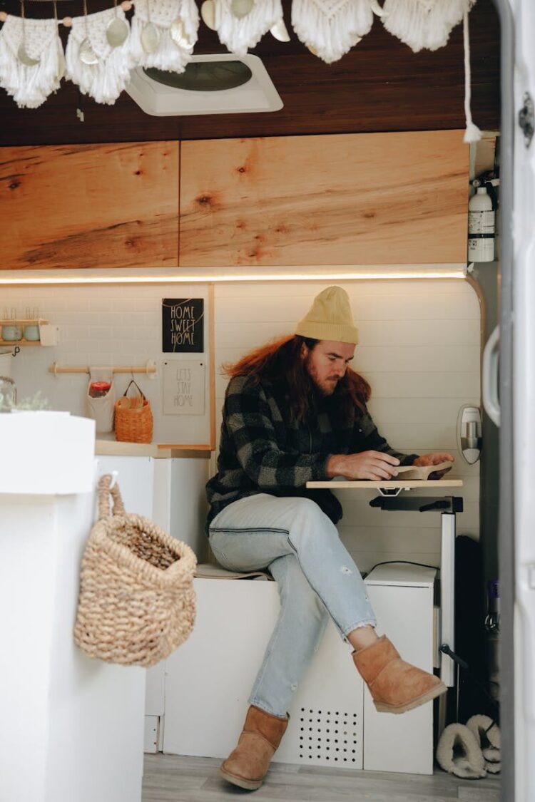 Person relaxing in a cozy camper van interior, reading a book. Perfect for van life enthusiasts.