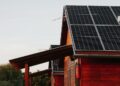 Wooden house featuring solar panels, captured at sunset, highlighting eco-friendly architecture.