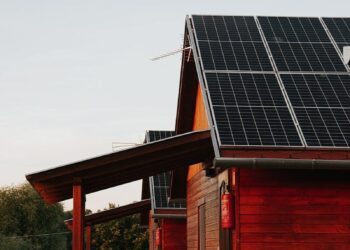 Wooden house featuring solar panels, captured at sunset, highlighting eco-friendly architecture.
