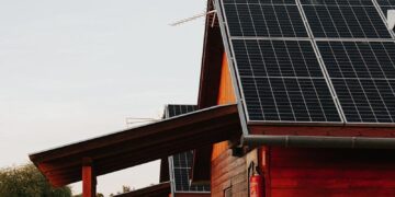 Wooden house featuring solar panels, captured at sunset, highlighting eco-friendly architecture.