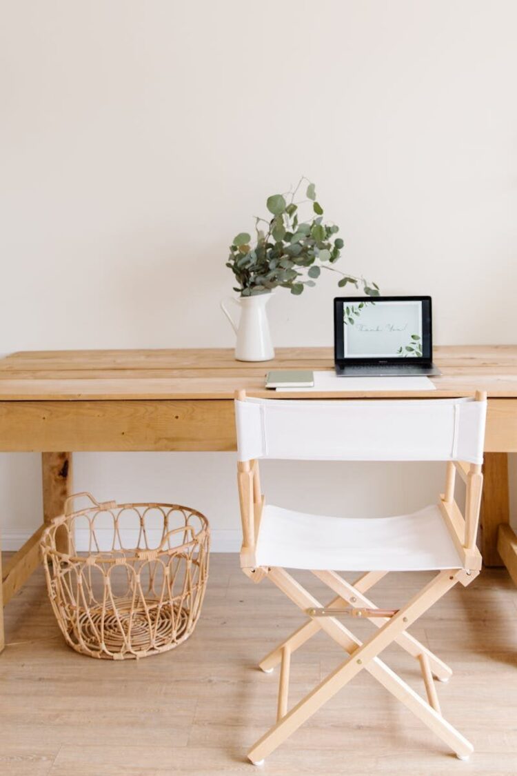Elegant minimalist home office with a wooden desk, chair, and tablet setup.