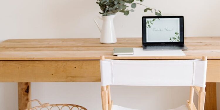 Elegant minimalist home office with a wooden desk, chair, and tablet setup.