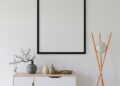 Elegant minimalist interior with empty frame, credenza, and modern decor.