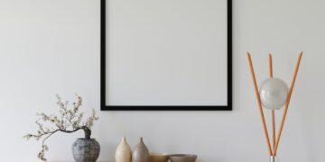 Elegant minimalist interior with empty frame, credenza, and modern decor.