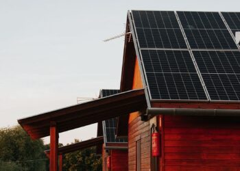 Wooden house featuring solar panels, captured at sunset, highlighting eco-friendly architecture.