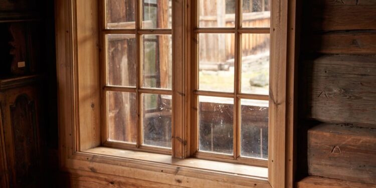 Warm rustic setting in a Norwegian log cabin, featuring a wooden window and sheepskin decor.
