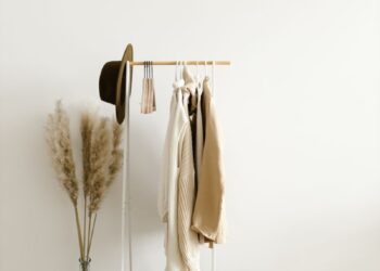 A chic minimalist clothing rack with neutral garments in a bright, modern setting.