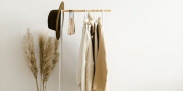 A chic minimalist clothing rack with neutral garments in a bright, modern setting.